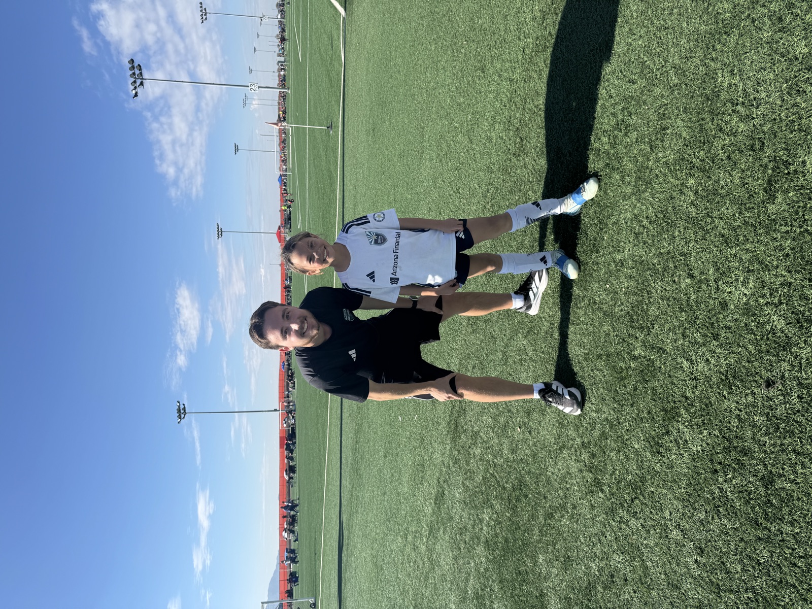 Coach David Fales standing with a young player in her game kit at a tournament.
