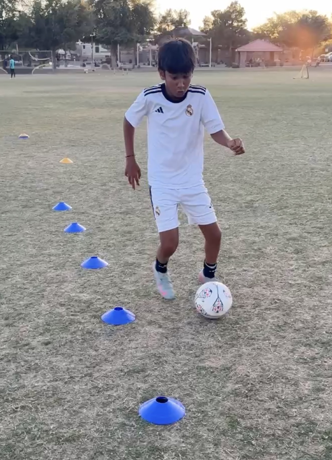 Coach David Fales demonstrating close ball control through cones.