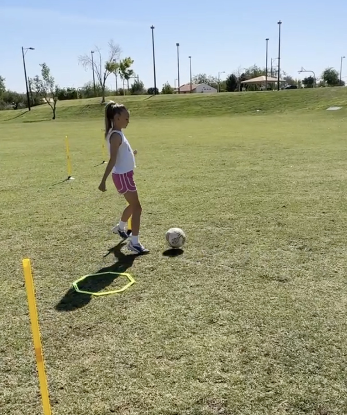 Young player dribbling through cones during a ball-control drill.
