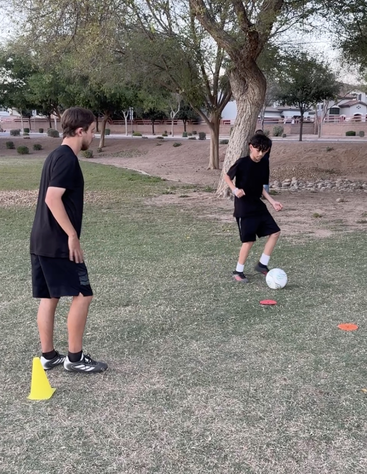 Coach David Fales running a passing drill with a player during an evening session.
