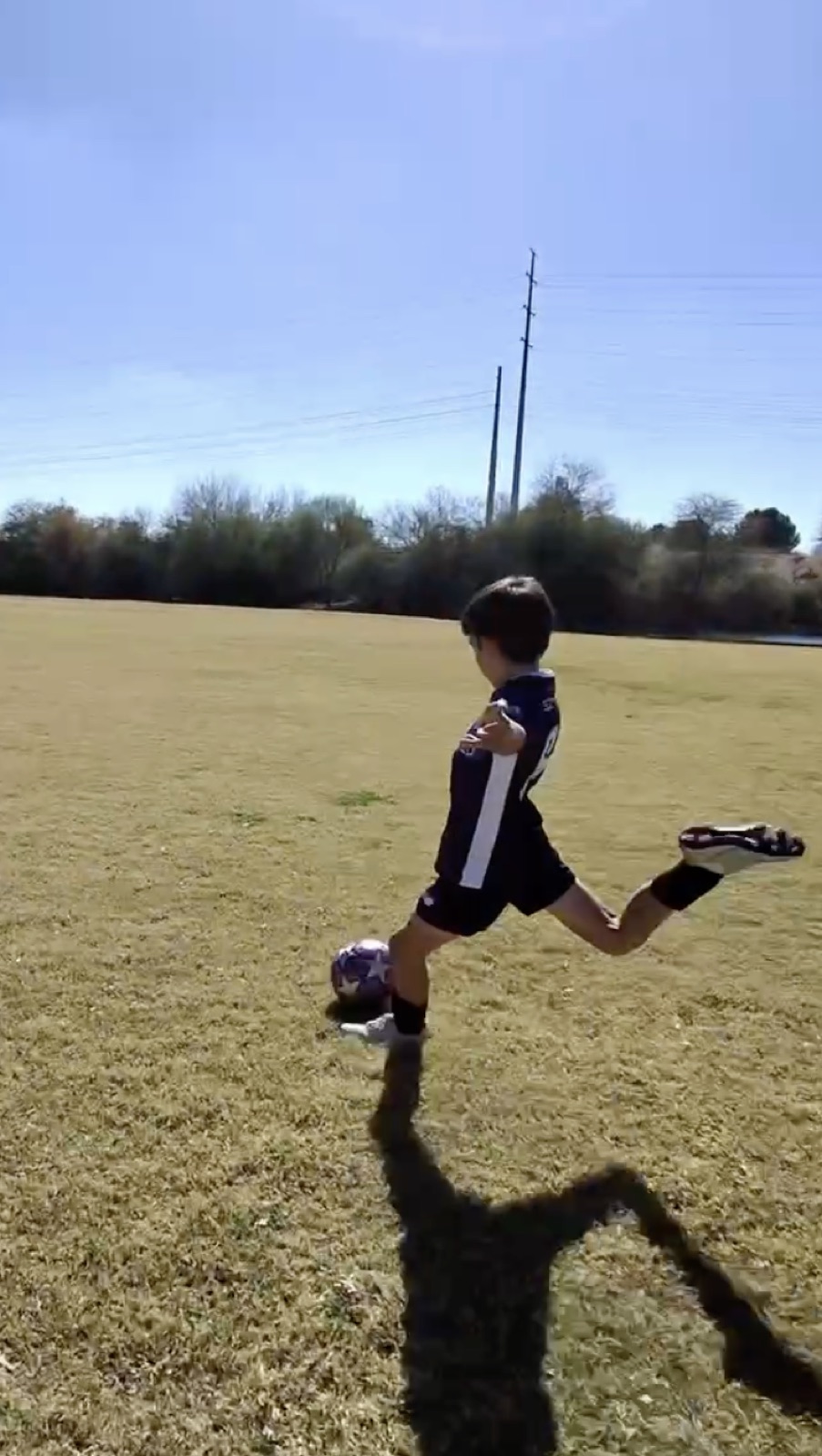 Youth player performing an explosive footwork move over a soccer ball.