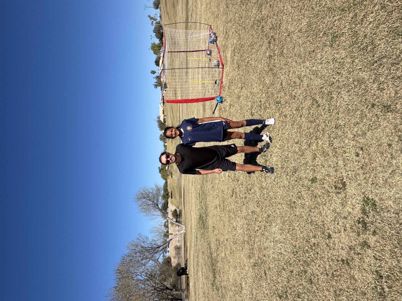 Coach David Fales standing with a youth soccer player next to a rebounder net during private training.