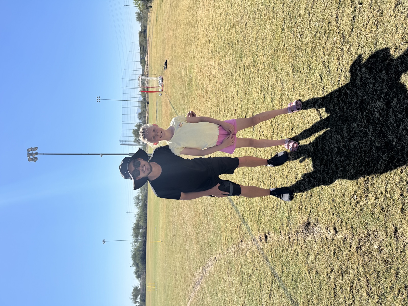 Coach David Fales with a young soccer player on the field before a private training session.