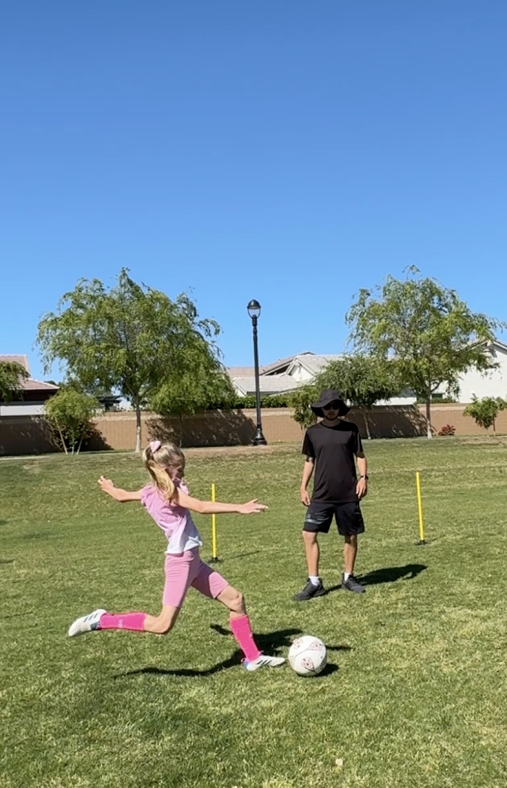 Young player stretching to reach a soccer ball during a training drill.
