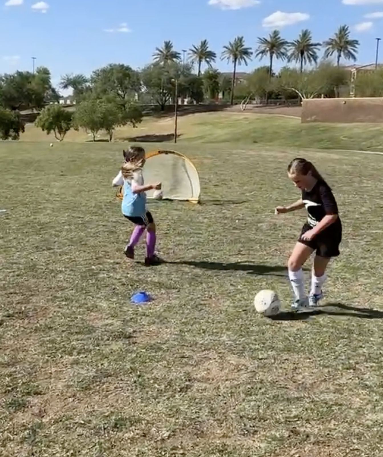 Two youth players in a 1v1 duel during a soccer training session.